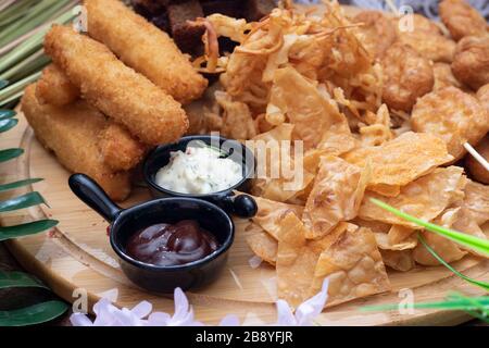Salty snacks. deried Pretzels, chips, crackers and two sauces Stock Photo