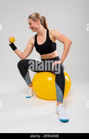 Pretty blonde girl with ponytail is training in sports clothes on