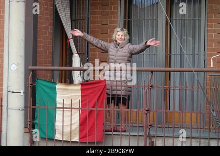 A lady in quarantine on the balcony of the house at the time of covid 19. Milan, Italy - March 2020 Stock Photo