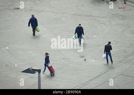 People back from shopping wearing masks to contain the spread of Coronavirus.  Milan, Italy - March 2020 Stock Photo