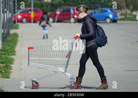 Coronavirus pandemic effects: woman in queue to enter the supermarket for grocery shopping. Milan, Italy - March 2020 Stock Photo