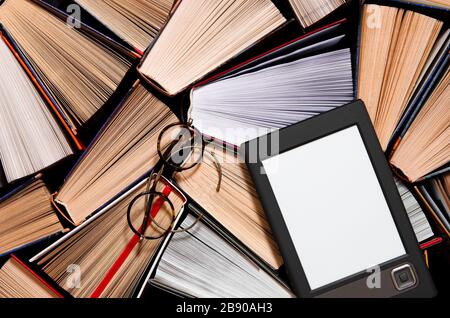 The e-book with a clean white screen rests on the open multi-colored books. ready to read Stock Photo