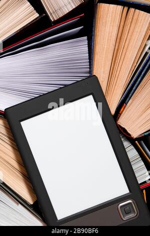 The e-book with a clean white screen rests on the open multi-colored books. ready to read Stock Photo