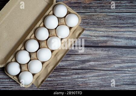 Chicken eggs in egg box on wooden rusty background Stock Photo