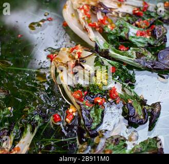 Charred Pak Choi with chilli and soy sauce on glass above grass Stock Photo