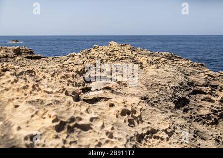 Texture of Volcanic rock surface in Cyprus look like moon surface. cliff, sea and sky background. selective focus. Stock Photo