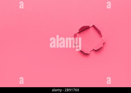 Pink color background with hole in the paper. Copy space Stock Photo