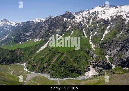 Mountains at Sughd at the end of the tunnel Takfon-Kalon in Tadzjikistan with snow and a river in the valley. Stock Photo