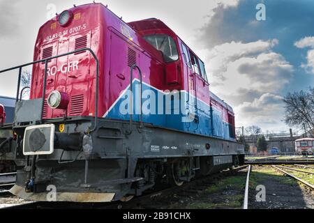 Red blue diesel locomotive stationary on railway. Blue sky in the background Stock Photo