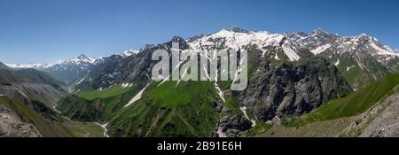 Panorama of the mountains at Sughd at the end of the tunnel Takfon-Kalon in Tajikistan with snow and a river in the valley. Stock Photo