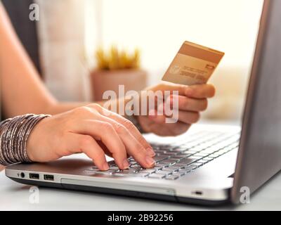Online shopping concept. Close-up woman's hands holding credit card and using laptop keyboard for online shopping Stock Photo