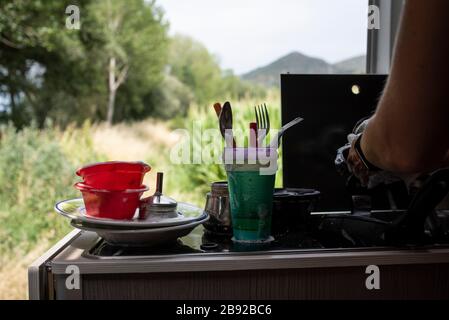 Close up of woman's hands washing dishes in motorhome. Stock Photo