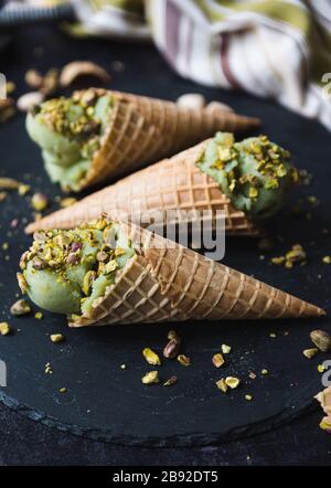 Close up of pistachio ice cream in cones on black background. Stock Photo