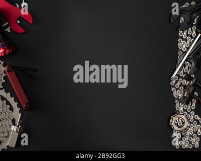 Work keys and spare parts for bicycle maintenance lie on a dark background. Text Placement Stock Photo