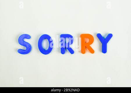 Sorry written in different colored letter blocks on an isolated white background Stock Photo