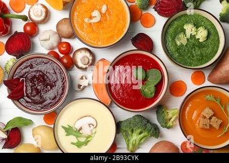 Vegetable soups and ingredients on white wooden background, top view Stock Photo