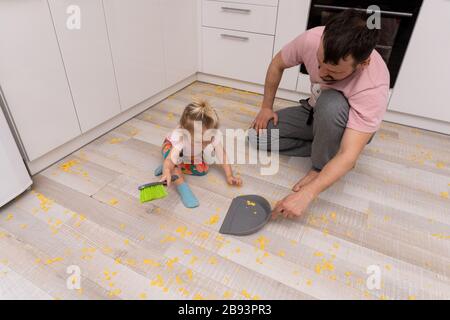 little girl helps her father with cleaning the floor Stock Photo