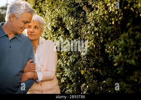 Mature couple standing arm in arm. Stock Photo