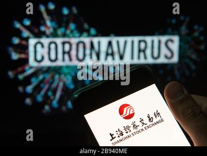 China. 20th Mar, 2020. In this photo illustration the Chinese Shanghai stock exchange index logo seen displayed on a smartphone with a computer model of the COVID-19 coronavirus on the background. Credit: Budrul Chukrut/SOPA Images/ZUMA Wire/Alamy Live News Stock Photo