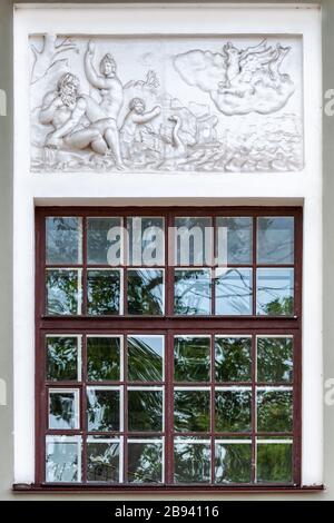 Rectangular window with stained glass and bas-relief on top. From the series Windows of Saint Petersburg. Stock Photo
