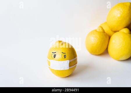 Lemon wearing medical mask isolated from the crowd. Conceptual image of social distancing. Stock Photo