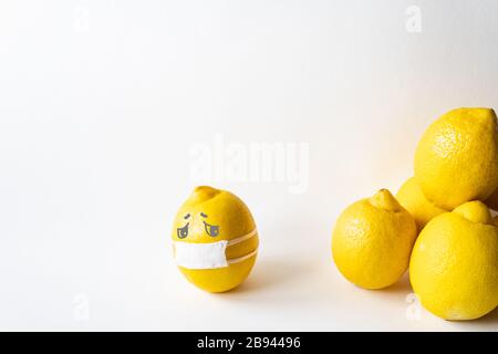 Lemon wearing medical mask isolated from the crowd. Conceptual image of social distancing. Stock Photo