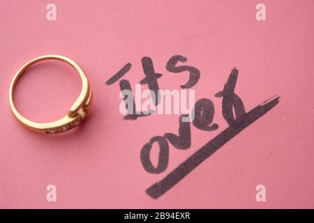 Divorce concept with wedding rings on pink background  Stock Photo