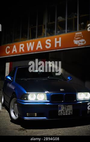 Tbilisi, Georgia August 11, 2019 Blue BMW e36 parked near car wash at night Stock Photo