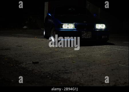 Tbilisi, Georgia August 11, 2019 Blue BMW e36 parked on the side of the road at night Stock Photo