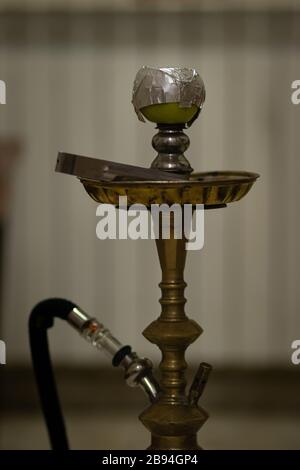 Bowl and head of Syrian hookah made of green apple, with foil on it. After use. Stock Photo