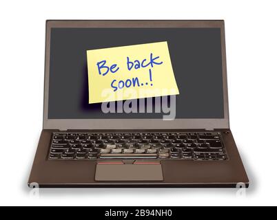Notebook pc with a yellow sticky note saying Be back soon on the empty screen. Computer isolated on white background. Stock Photo