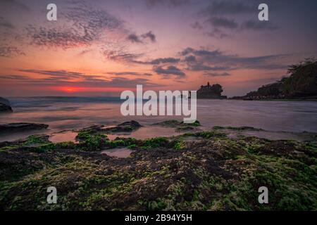 Pura Tanah Lot Temple, Bali at sunset. For the Balinese, Pura Tanah Lot is one of the most important and venerated sea temples. A long exposure photograph. Stock Photo