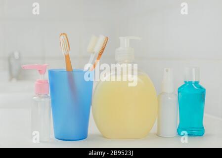 bathroom with cosmetic soap, liquid rinse in bottles and toothbrushes for morning treatments Stock Photo