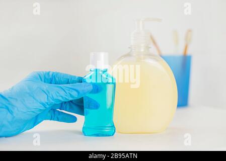 bathroom with cosmetic soap, liquid rinse in bottles and toothbrushes for morning treatments Stock Photo