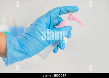 antibacterial protective agent antiseptic in the hands of a girl in blue gloves against infections and germs Stock Photo
