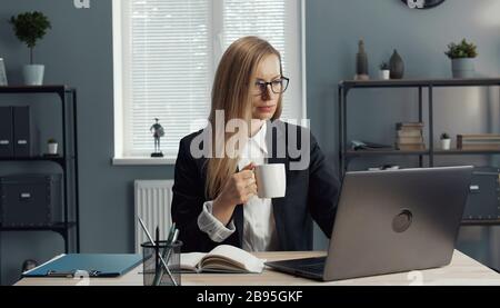 Businesswoman having coffee while working Stock Photo