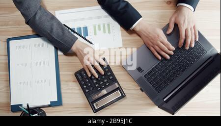 Three hands during accounting process Stock Photo