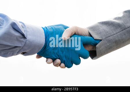Shaking Hands In Gloves During Coronavirus Pandemic Stock Photo