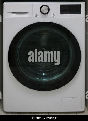 New electronic washing machine front view with dark glass door Stock Photo