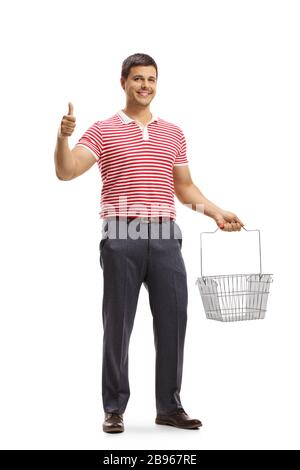 Full length portrait of a young man holding an empty shopping basket and gesturing thumb up sign isolated on white background Stock Photo