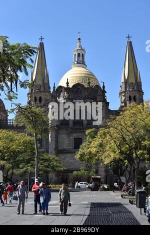 Pedestrians on the Plaza de la Liberación, behind Guadalajara's grand cathedral. Stock Photo