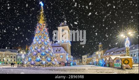 Brasov, Romania- 06 January 2019:Christmas Tree in the old city center of Brasov in a snowing night,Panoramic view of the old town and  Council Square Stock Photo