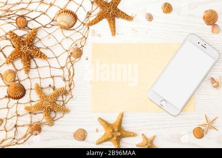 Summer time concept with sea shells and starfish on a white wooden background. Stock Photo