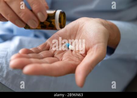 Close up of mature woman taking medicines at home Stock Photo