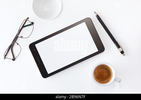 Desk with laptop, eye glasses, earphone, pen and a cup of coffee. Top view with copy space. Stock Photo