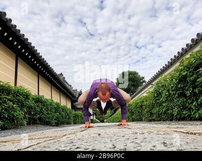 Man doing yoga pose on the street Stock Photo
