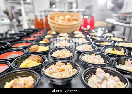 Row of plastic disposable lunch box with healthy natural food. Soups, cream soup, main course with side dish, salads. Food delivery. Lunch in the Stock Photo