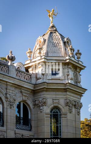 Gold Cupid Statue on top of Square Jean Perrin in Jardin des Champs Elysees, Paris, France Stock Photo