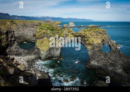 Famous rock arch Gatklettur at Snaefellsnes Iceland coast on sunny day with cloudy sky. No people visible, copyspace. Stock Photo