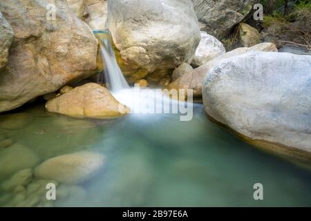 small waterfall among stones on mountain stream Stock Photo